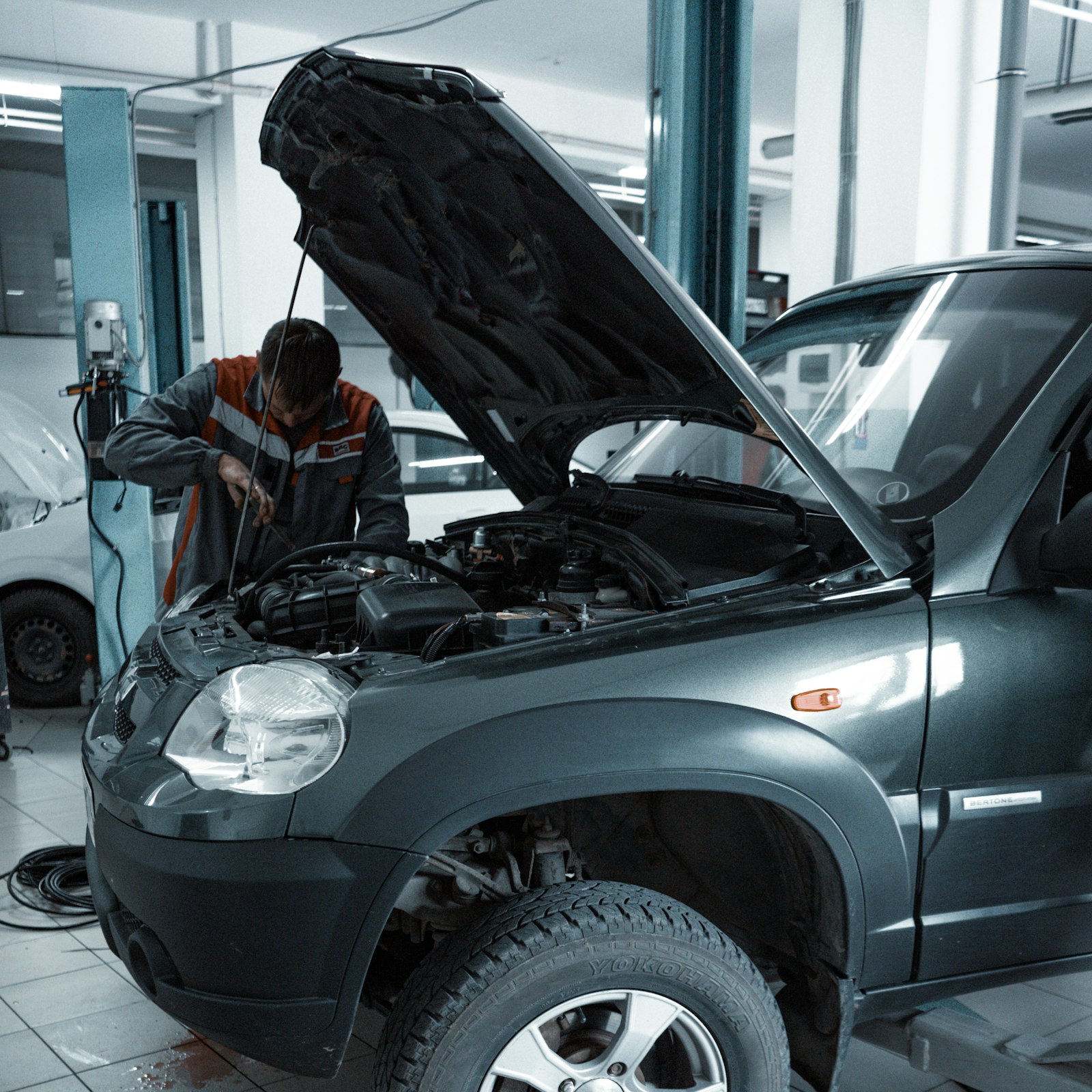 Technician checking over a vehicle under the bonnet