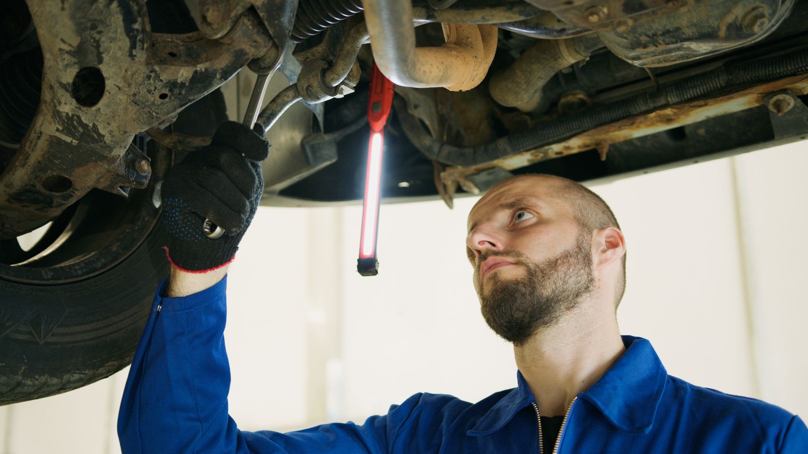 Mechanic using a wrench while servicing a car